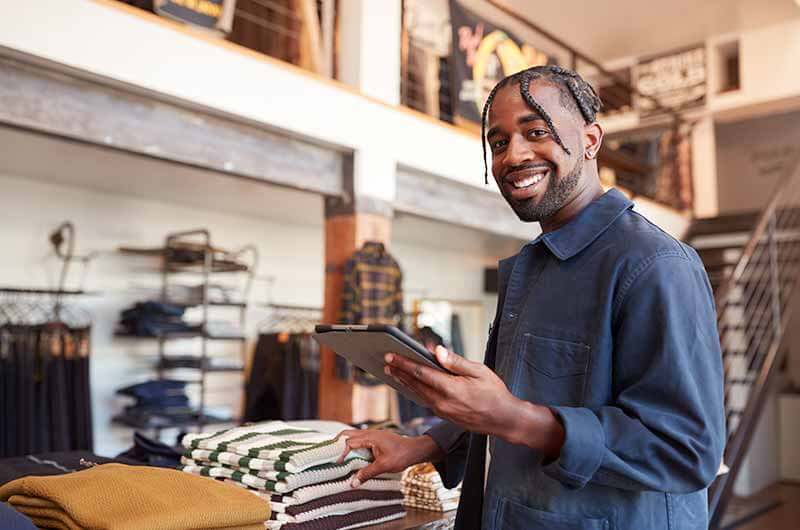 African American man using tablet in clothing store